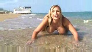 Piersiata europejska laska Carol Goldnerova bawi się swoimi piersiami na nagiej plaży.