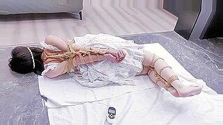 Shibari benutzt Bondage-Techniken, um eine geknebelte und gefesselte Brünette zu befriedigen.